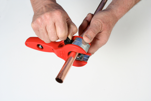 Một máy cắt ống ratchet cắt qua ống đồng.
